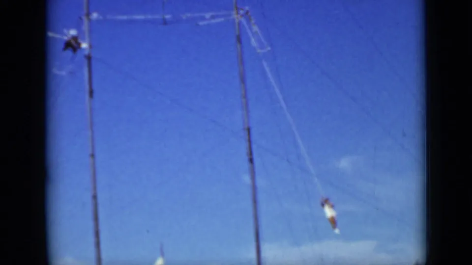 Distant 1937 San Francisco aerial act with performers on ropes near tall poles, seen from a low home-movie angle.