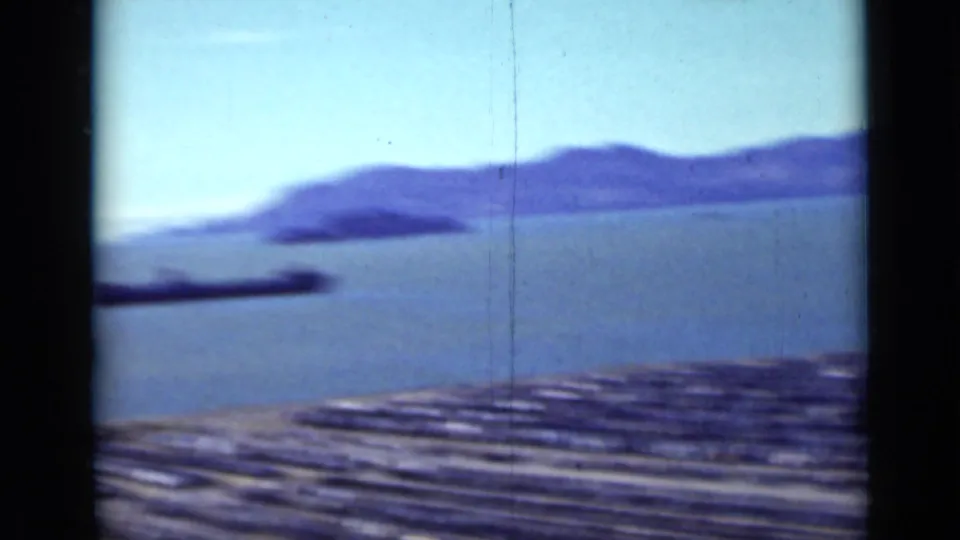 Soft 1937 San Francisco bay view with distant hills and a crowded waterfront parking area along the lower edge.