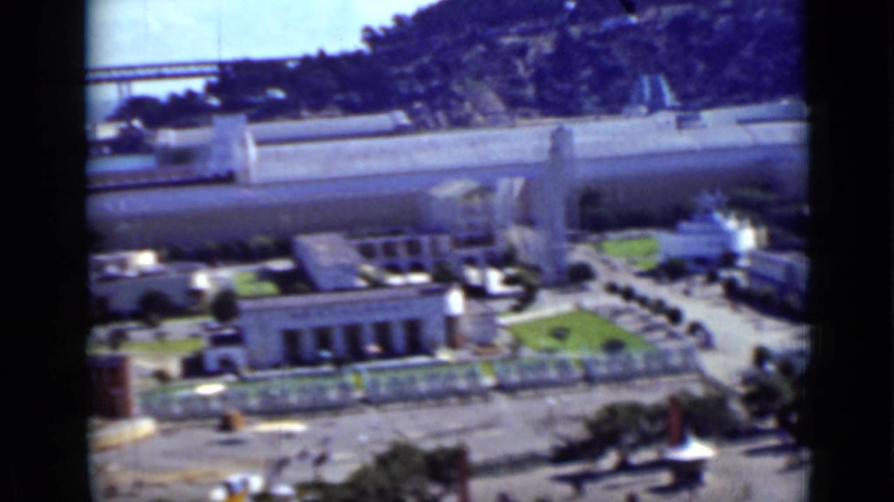 Elevated view of San Francisco grounds with a bridge and hillside in the distance.