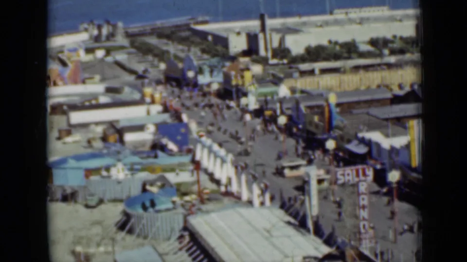 1937 San Francisco seaside amusement scene with visitors on a promenade, colorful structures, rooftops, and Sally Rand signage.