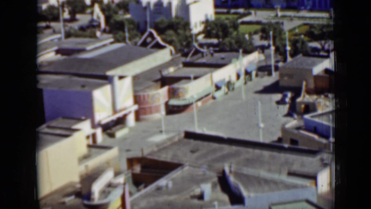 San Francisco 1937 frame showing rooftops, pale buildings, open pavement, and landscaped grounds from above.