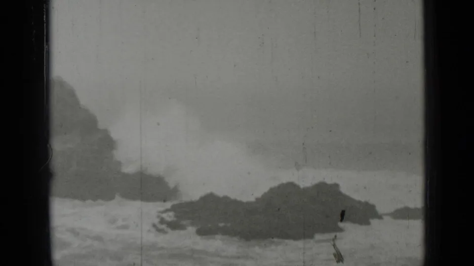 Archival 1937 San Francisco frame showing turbulent surf and dark rocks in a soft 8mm home-movie view.