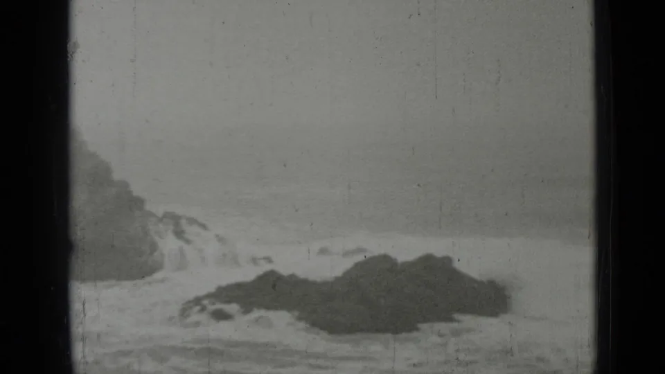 1937 8mm home-movie view of a rocky San Francisco shoreline with surf breaking in soft focus.