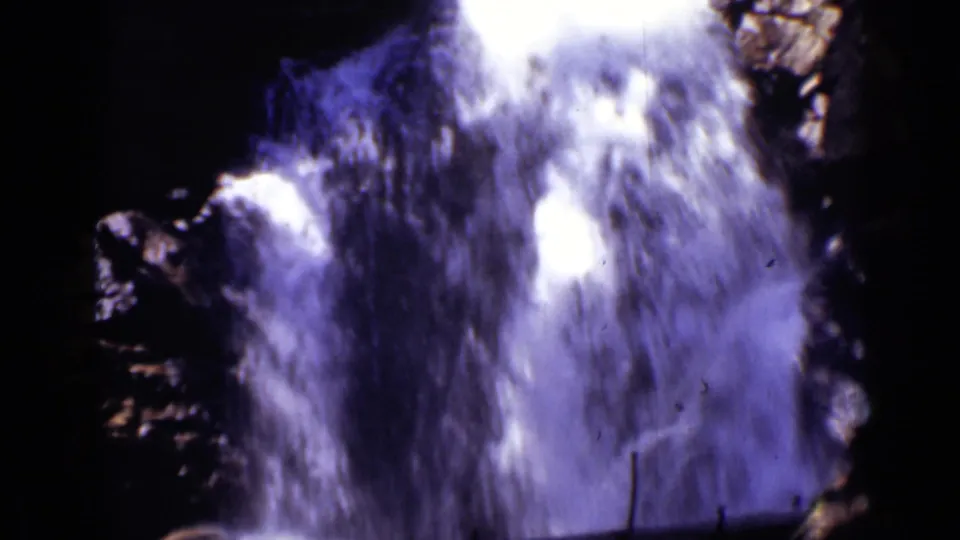 1938 Colorado 8mm frame showing swift white water pouring over dark rock in bright sunlight.