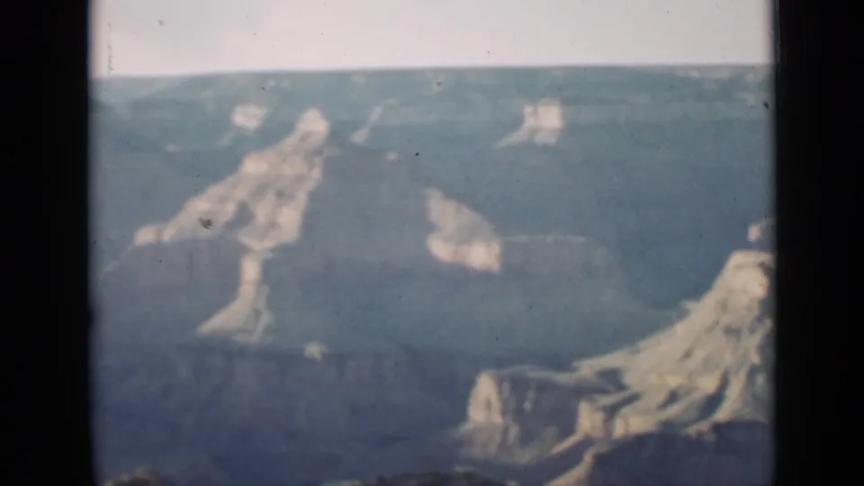 1939 Arizona 8mm frame with pale Grand Canyon rock forms, distant rim, and soft blue faded exposure.