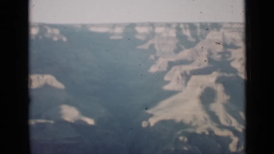 1939 Arizona 8mm frame with broad Grand Canyon forms, pale rock shelves, and deep blue-gray shadows.