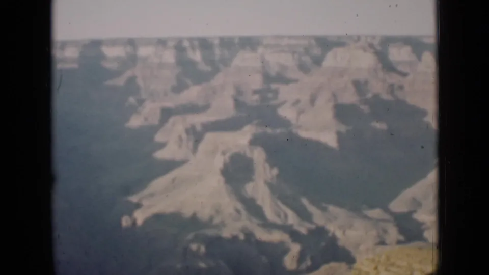 1939 Arizona 8mm frame showing wide Grand Canyon terraces and ravines with dust marks and muted color.