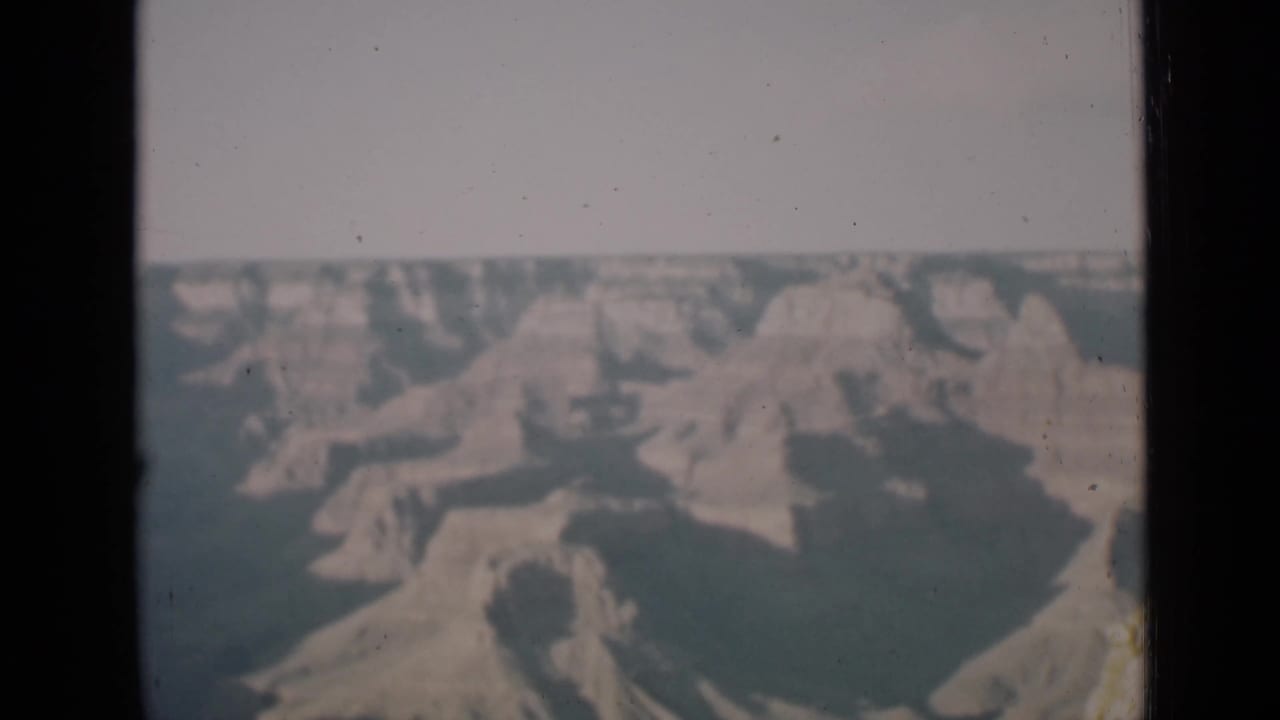 Another soft color view of canyon formations framed by dark film edges.