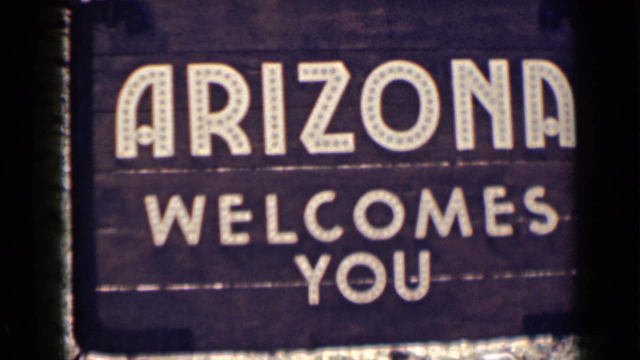 Arizona Welcomes You sign with white lettering on dark wood.