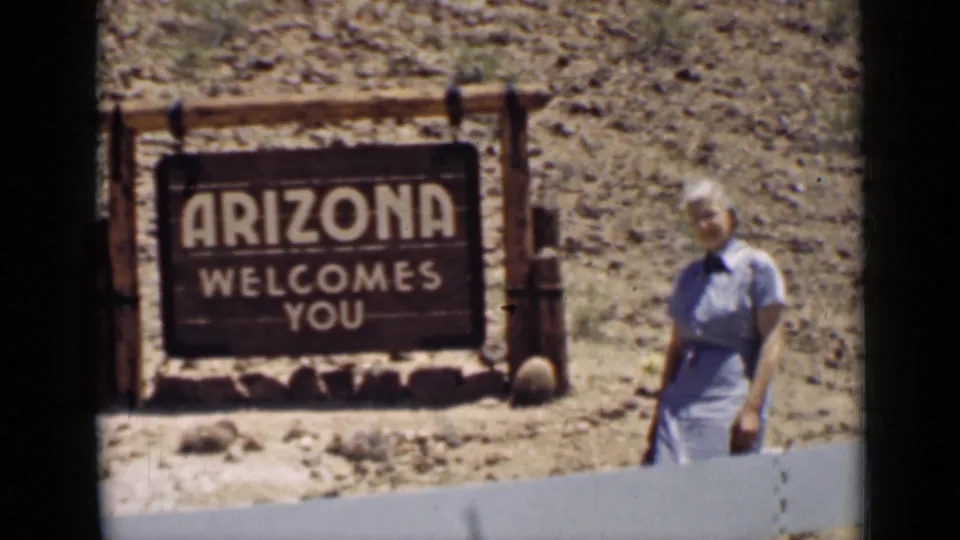 Arizona, 1939, showing the state welcome sign, desert rocks, and a woman posing during a home-movie road stop.