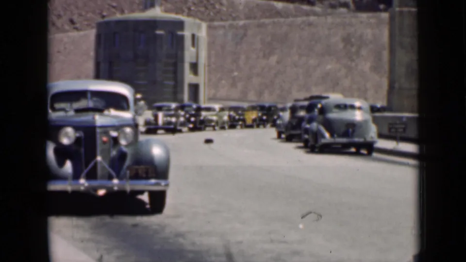 Late-1930s automobiles appear lined up near a large concrete structure in Arizona archival home-movie footage.