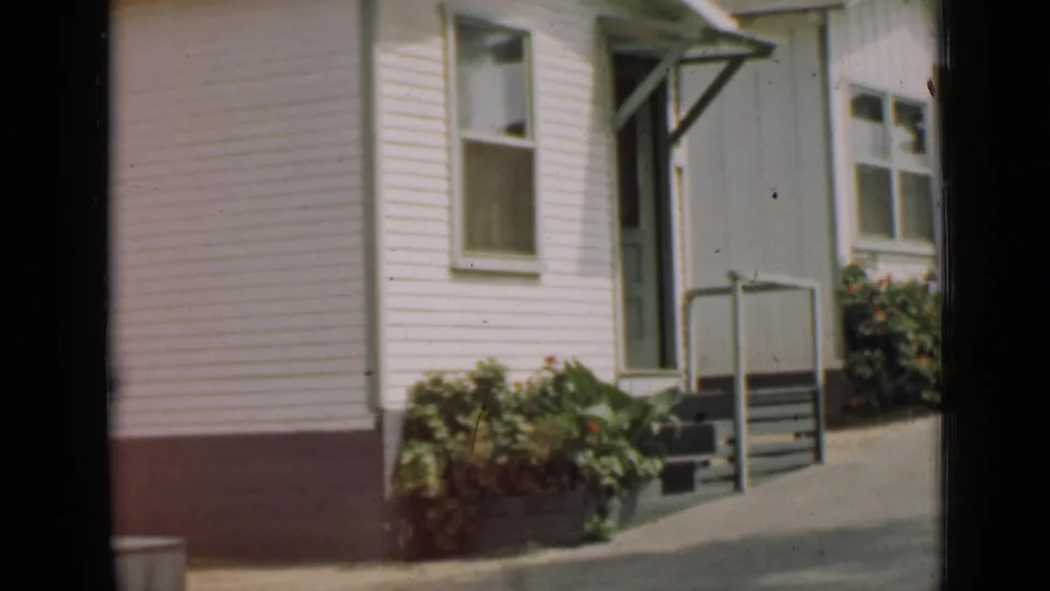 The final frame shows the Arizona house exterior after the woman has moved from view, with steps, windows, and shrubs visible.