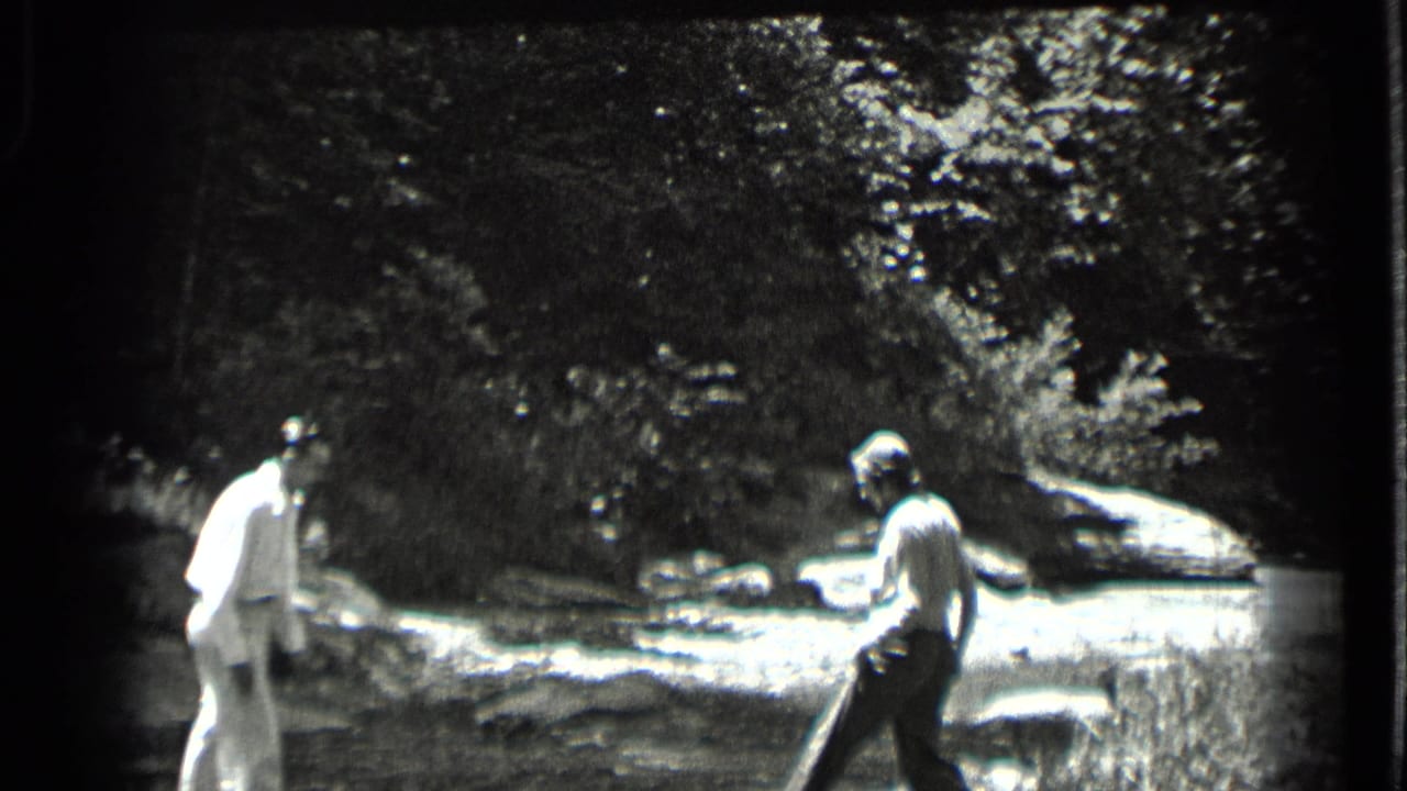 At Clear Lake, two adults appear near a shallow rocky stream, preparing to help each other across the water.