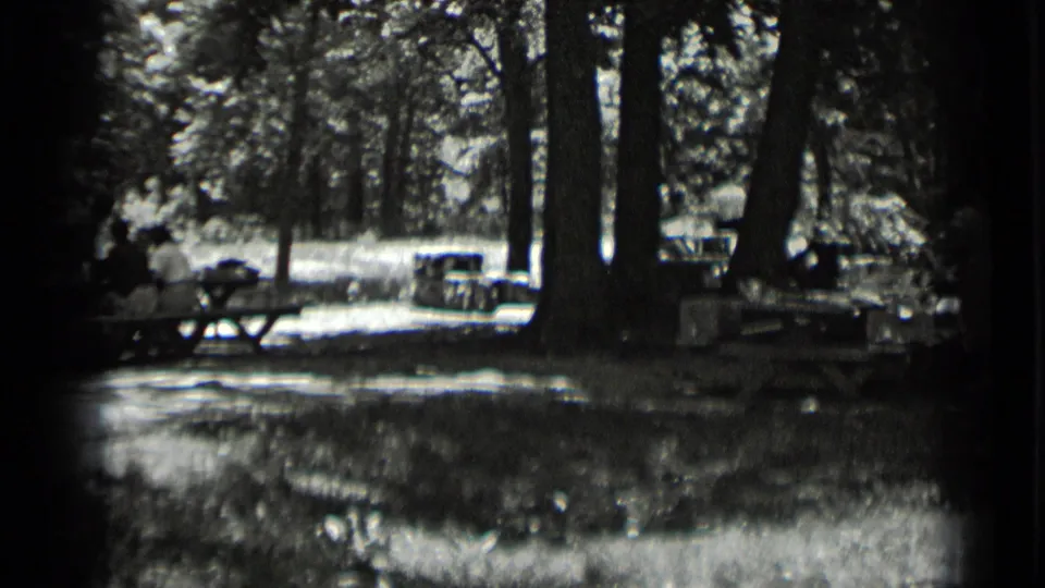 Clear Lake campground footage shows seated people near picnic tables under tall trees in 1939 home-movie frames.