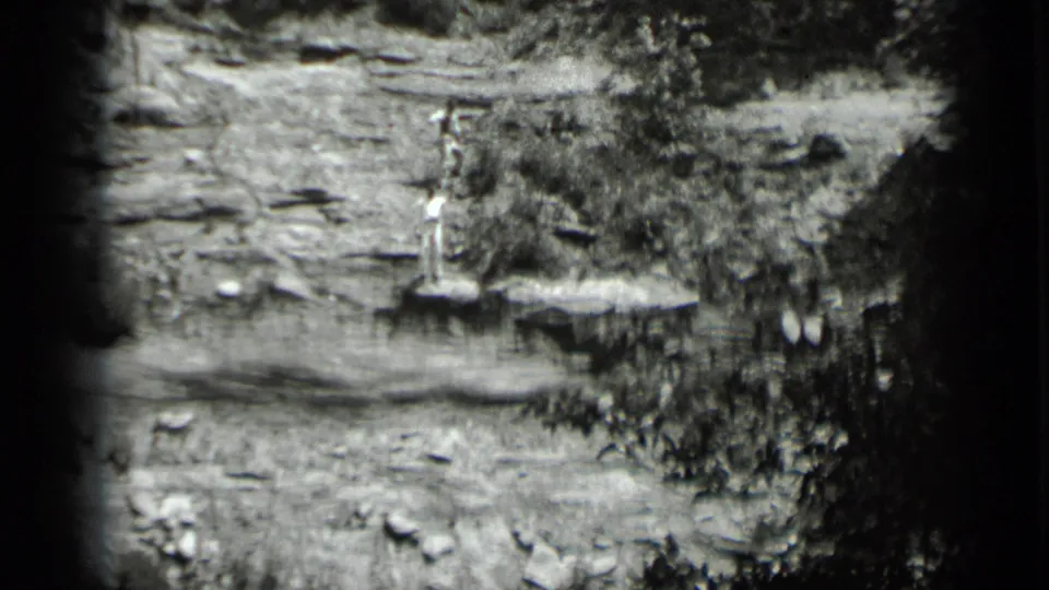 Final 1939 Clear Lake frame holds on the distant figure on a rocky ledge, with scrub plants and heavy 8mm vignetting visible.