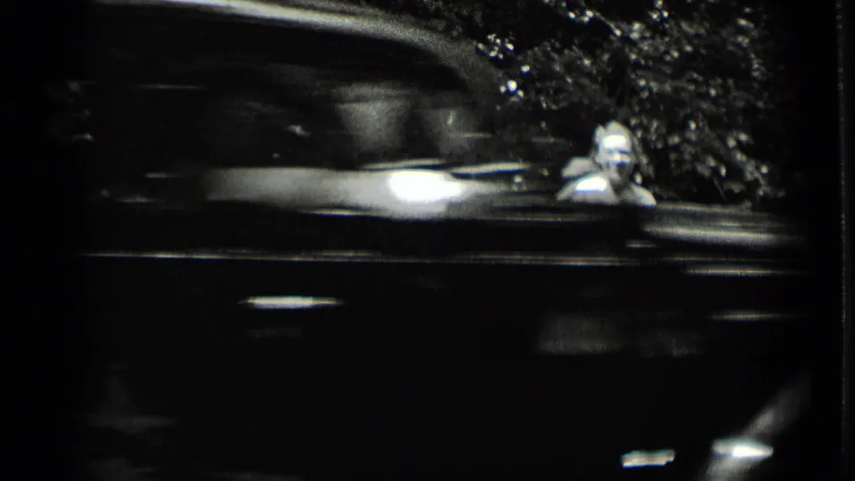 A motion-blurred car passes through a wooded Clear Lake, California home-movie frame from 1939.