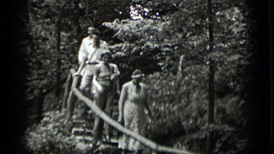 Adults walk down rustic wooden stairs in a wooded Clear Lake, California setting in 1939 home-movie footage.