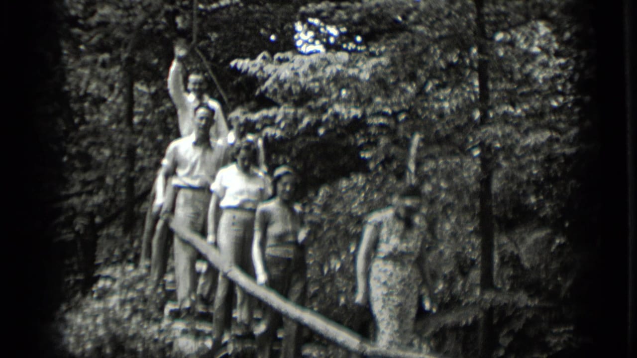 A group pauses or walks on wooden stairs in 1939 Clear Lake footage, with one adult raising an arm toward the camera.