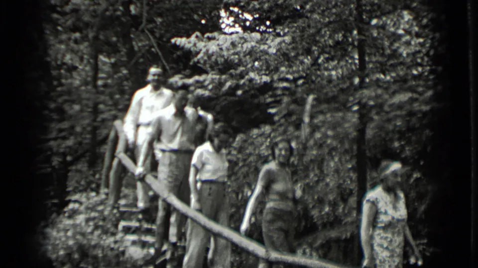 Adults in light clothing descend and gather along rustic stairs in wooded Clear Lake, California home-movie footage from 1939.