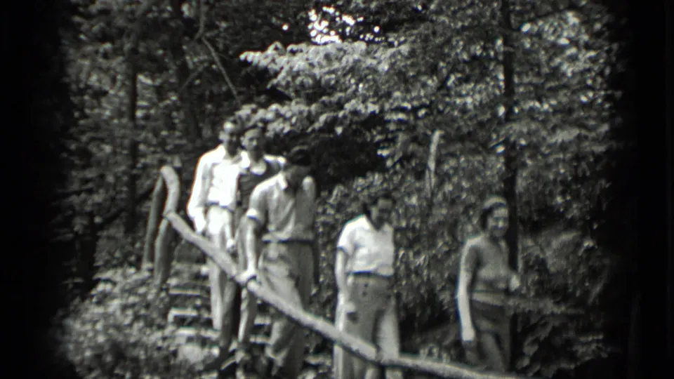 Adults in light clothing walk down forest stairs near Clear Lake, California, in 1939 home-movie footage.