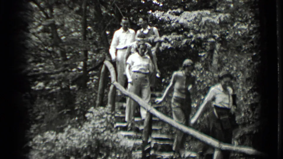 Adults in period casual clothing occupy the wooded stair path at Clear Lake, California, in black-and-white 8mm footage from 1939.