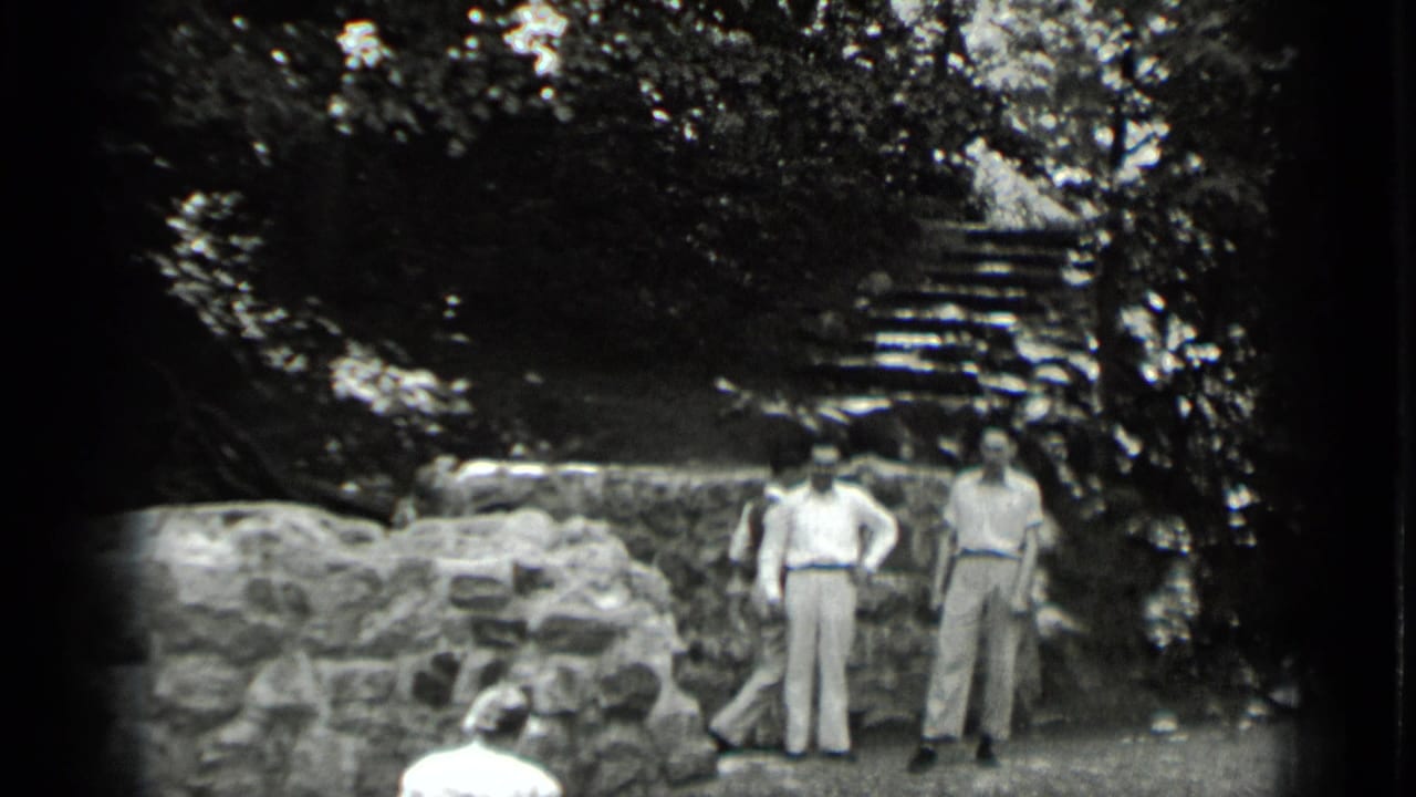At the bottom of the Clear Lake stairway, two adults stand near a low stone wall while steps rise into the trees behind them.