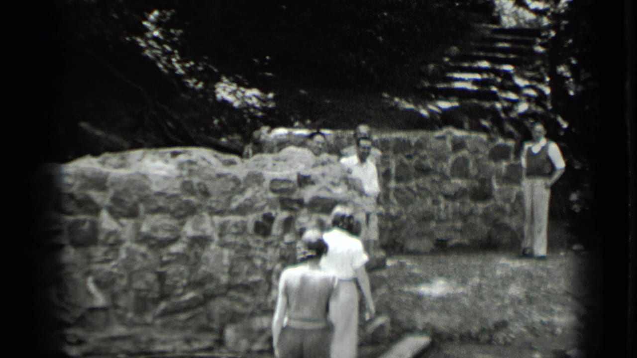 Women walk across the foreground toward men at a stone ruin in 1939 Clear Lake, California home-movie footage.