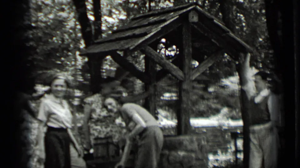 At the end of the Clear Lake clip, two young adults stand by the well as another bends near the bucket area.
