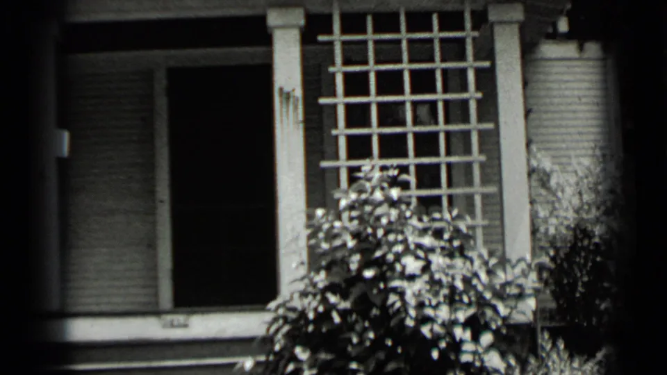 A close porch view from the 1939 Clear Lake footage shows a dark doorway, trellis, shutters, and garden foliage.