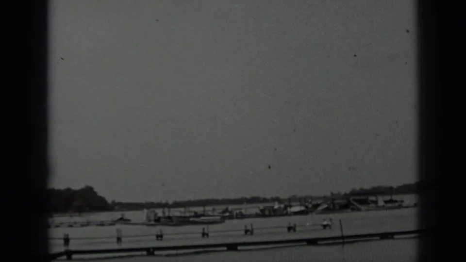 Clear Lake shoreline in 1939 home-movie footage, with boats clustered near a pier and hills in the distance.
