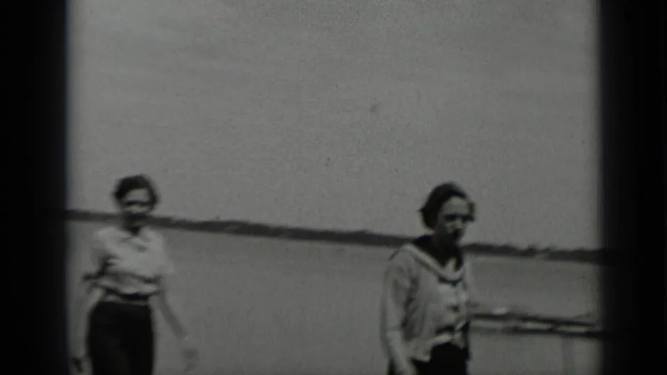 The two women pass close to the camera on the Clear Lake pier, with soft focus and lake water behind them.