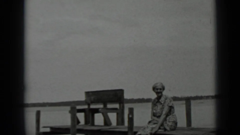 In the final frame, a woman sits on the Clear Lake dock facing the camera, with calm water and a low shoreline in view.