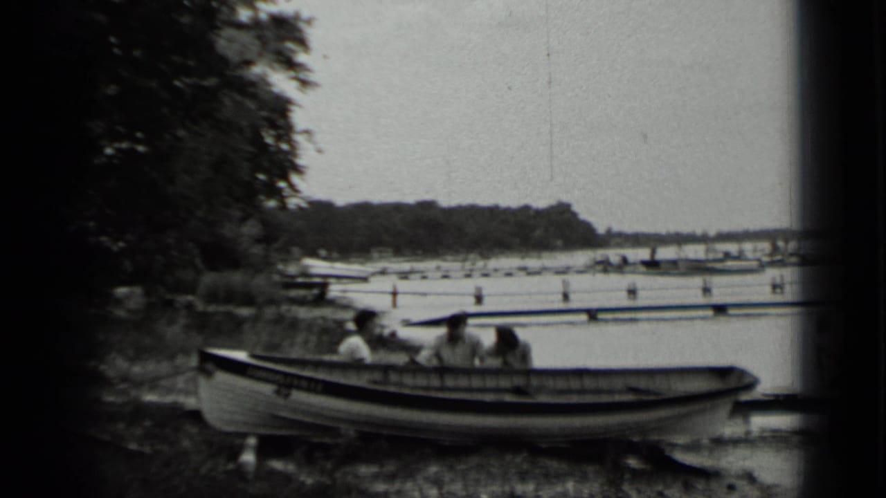 A small boat with people aboard sits near the Clear Lake shore, with trees, docks, and water visible in the background.
