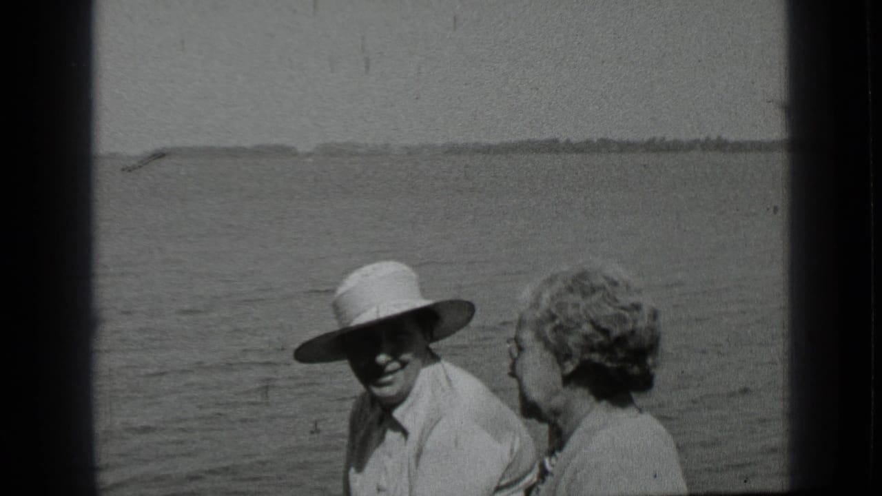 At Clear Lake in 1939, a man in a broad hat sits near a woman on a boat with open water and shoreline in the background.