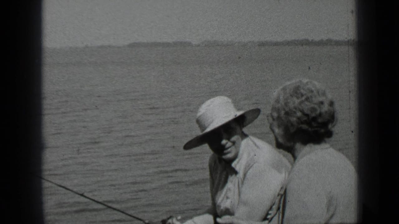 The man in a hat looks toward the woman as a fishing rod extends across the Clear Lake boat scene.
