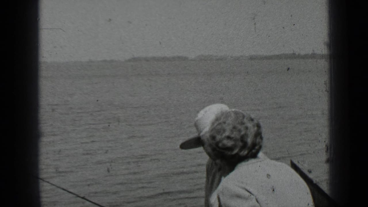 Two adults in a small boat face the lake at Clear Lake, California, in a black-and-white 1939 home-movie frame.