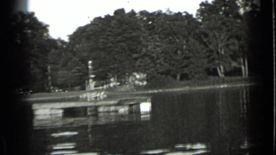 Clear Lake shoreline view from a moving boat, showing water, trees, and a small dock or lakeside structure in 1939 home-movie footage.