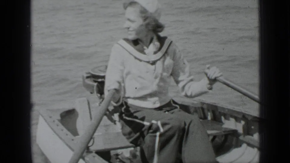 A woman in sailor-style clothing smiles in a rowboat on Clear Lake, California, in 1939 home-movie footage.