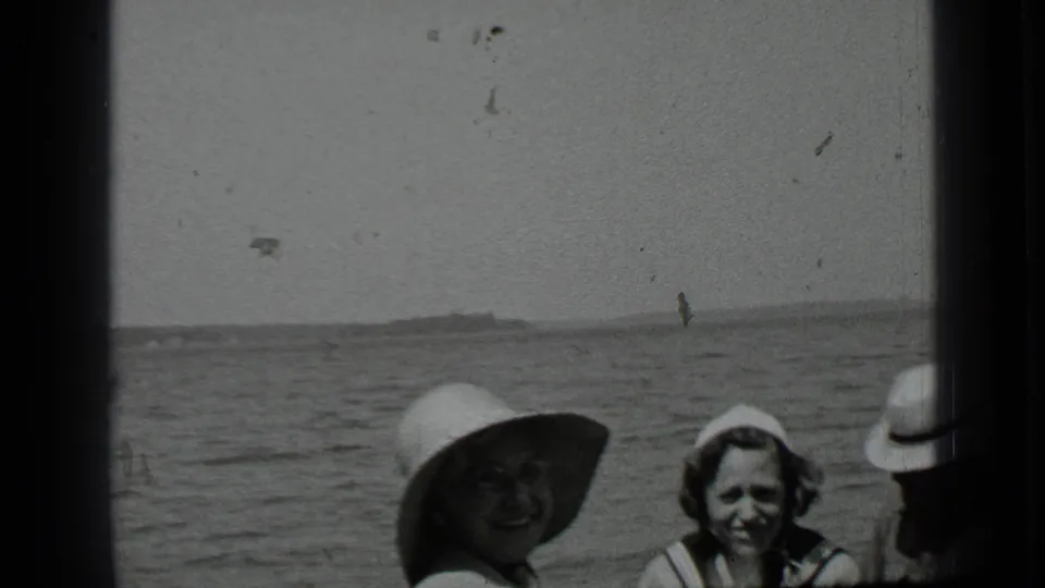 1939 Clear Lake frame with two family members facing the camera in hats while another person is partly cropped at the edge.