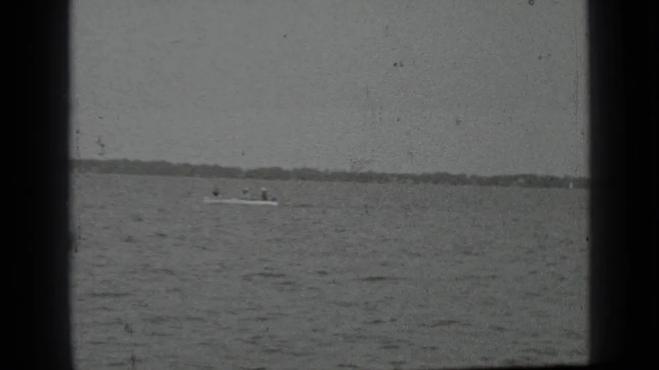 1939 Clear Lake home-movie frame showing a small motorboat with people aboard on open water under a cloudy sky.