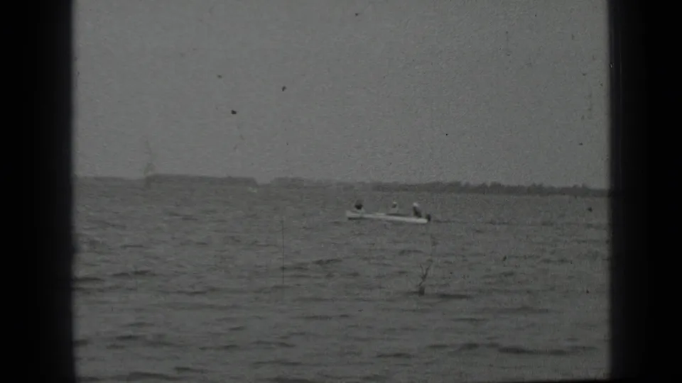 Final frame shows a motorboat with riders on Clear Lake, with soft 8mm grain and a muted cloudy background.