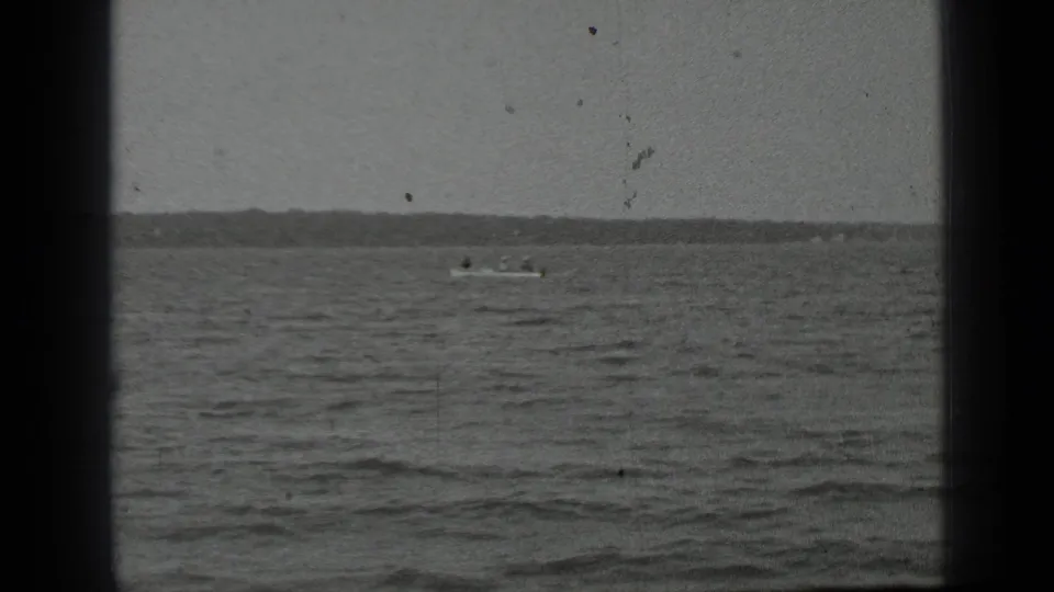 The boat sits far across Clear Lake in a grainy 1939 frame, with broad water, distant shore, and visible 8mm film borders.