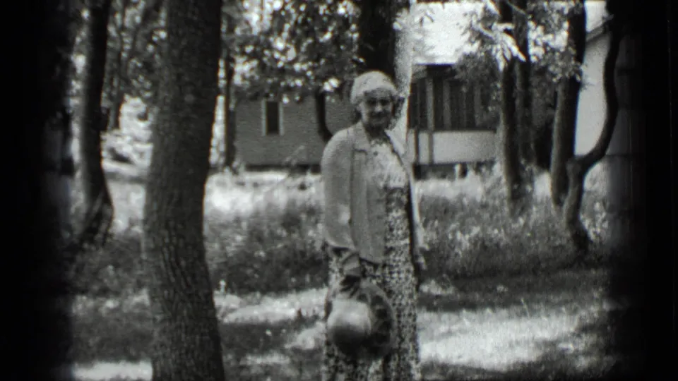 A 1939 Clear Lake frame shows a woman facing the camera in a wooded yard, with a house or cabin visible behind the trees.