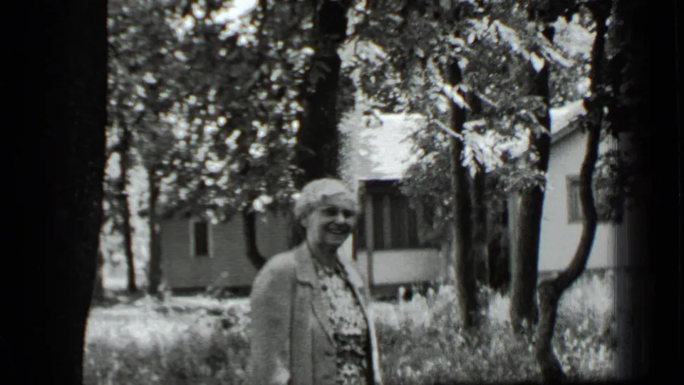 The final frame shows the woman smiling in the wooded Clear Lake yard, framed by dark tree trunks and a nearby house.