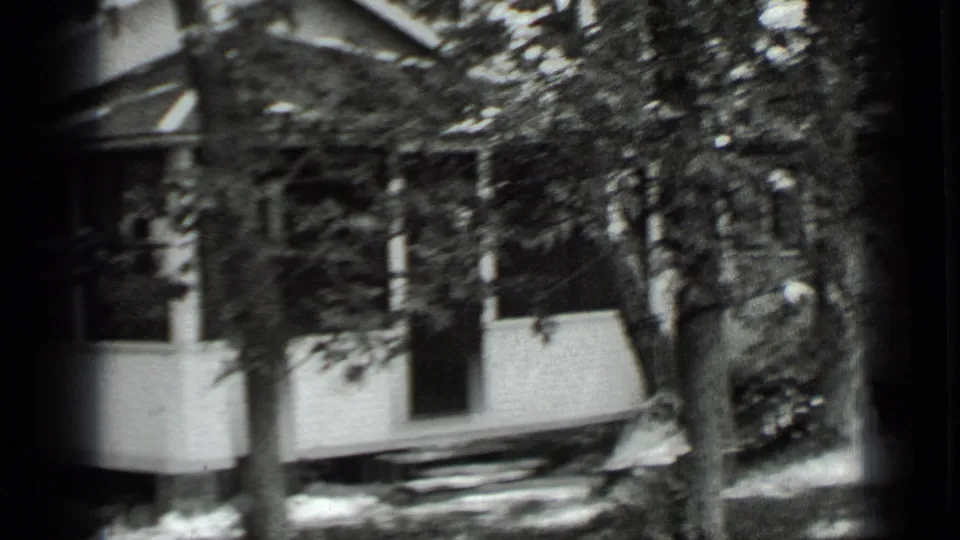 Late frame from the 1939 Clear Lake pan, with the white porch, trees, and yard softened by motion blur.