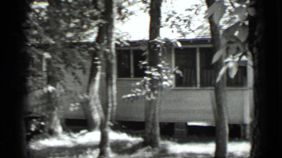 White house exterior and shaded windows appear behind trees in 1939 Clear Lake footage.