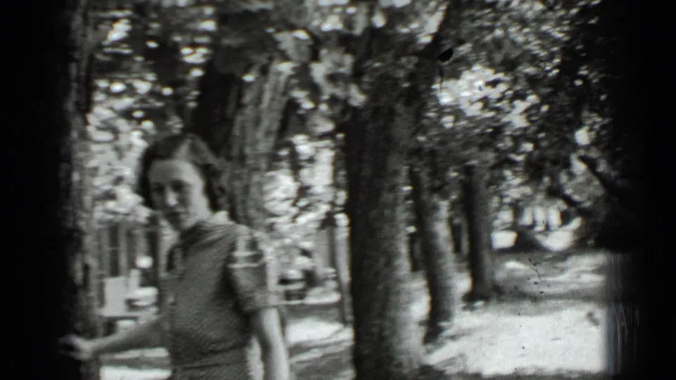 Adult woman moves out of the central frame while walking through trees at Clear Lake, California, in 1939.