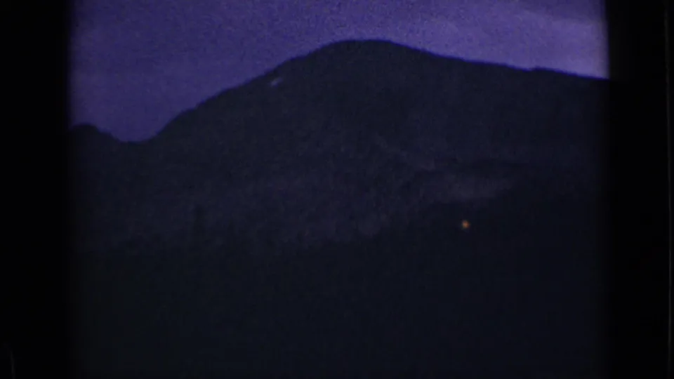 1939 Colorado 8mm frame showing a rounded mountain profile in low light, with purple cast and heavy film grain.