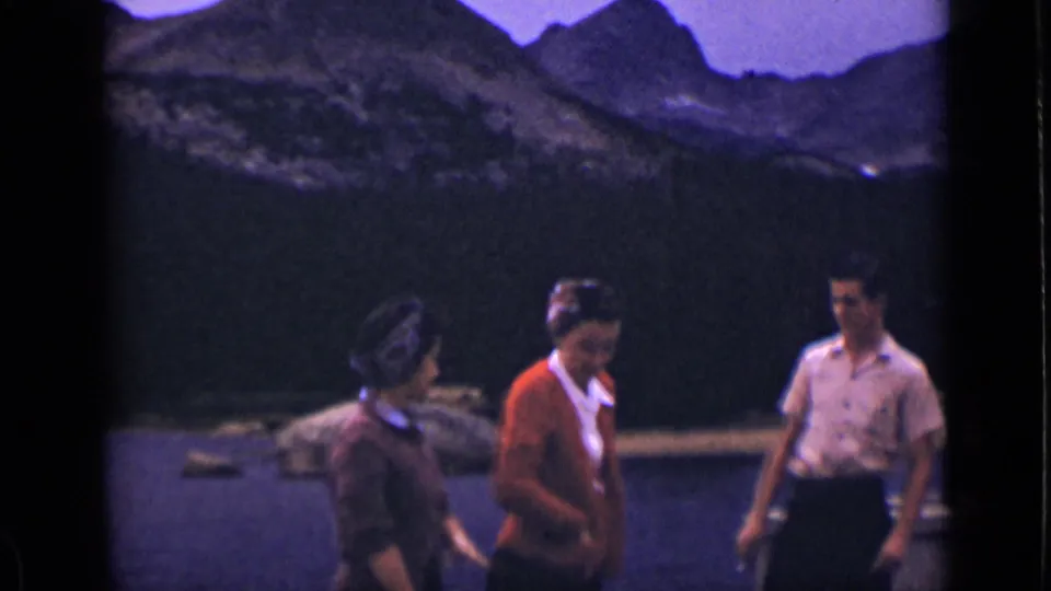 A woman in a red cardigan stands between another woman and a man on a Colorado lakeside dock, based on the 1939 clip metadata.