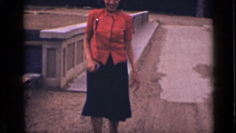 Near the end of the clip, the woman approaches close to the camera, with the concrete ramp and railing receding behind her.